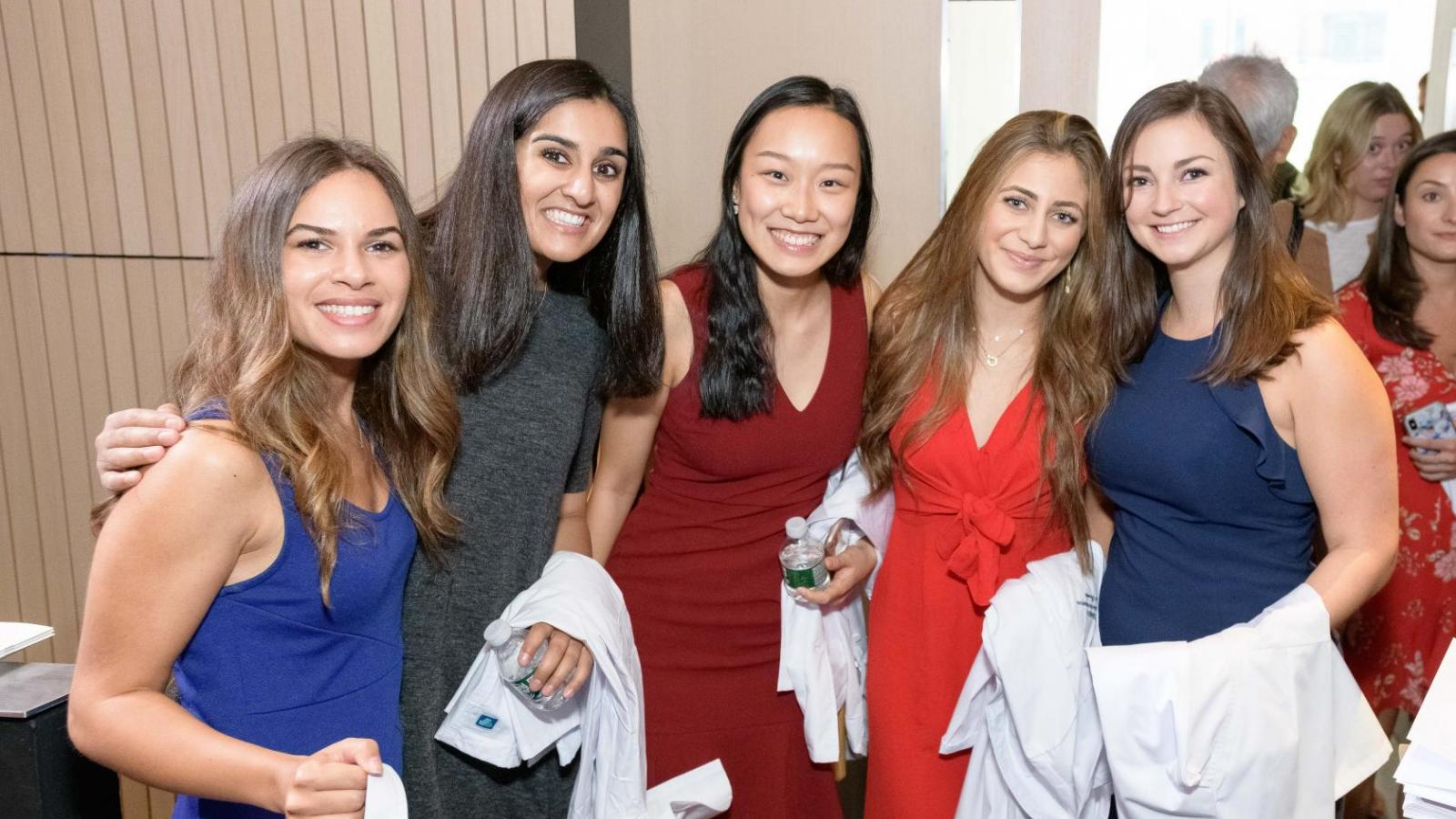Students holding white coats