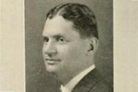 A headshot of a white man who is looking sideways