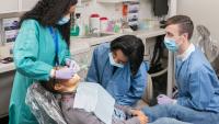 faculty member giving a dental exam, two residents observing
