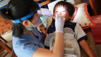 dentist examining a child in a developing country