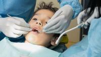 pediatric patient being examined in dentist chair