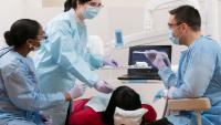 faculty instructing two residents during dental exam