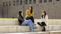 Students sitting on steps outside a building.