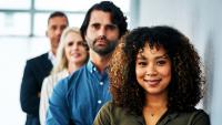 Portrait of a group of diverse people standing in line in a modern office