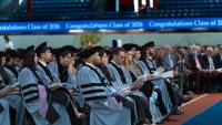 Graduates sitting during their ceremony listening to speaker