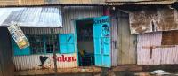 Photo showing a tin-roofed salon on a flooded street in Nairobi