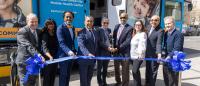 Public officials and university leadership cut a ribbon with big scissors to launch a new mobile health van