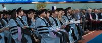 Graduates sitting during their ceremony listening to speaker