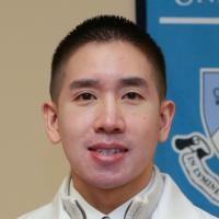 An adult male of Asian descent with a college of dental medicine banner in the background