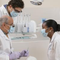 Professor conversing with dental students in a clinic